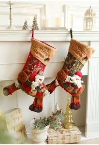 Vue détaillée des poupées 3D renne et Père Noël en peluche sur des chaussettes de Noël