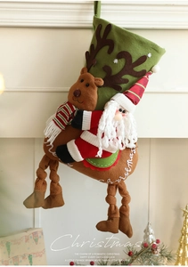 Gros plan sur la chaussette de Noël en peluche verte avec Père Noël et renne en 3D