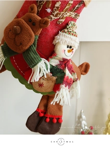 Gros plan d'un renne et bonhomme de neige en peluche 3D sur une chaussette de Noël
