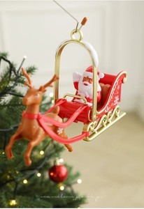 Rotating tree topper featuring Santa in a red sleigh pulled by a reindeer with gold accents