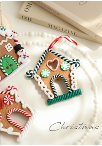 Close-up of gingerbread house ornament with pink heart window and festive candy stripes