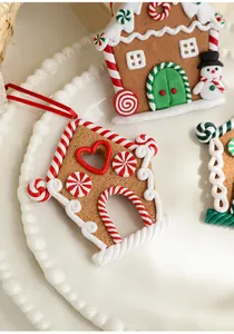 Macro detail of clay gingerbread house ornaments with white icing texture and red heart window