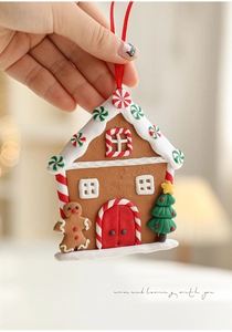 Handheld gingerbread house ornament with candy canes and red ribbon for Christmas trees