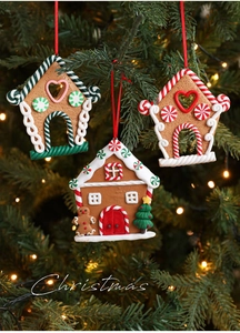 Detailed view of gingerbread house ornaments hanging on a Christmas tree with warm lights