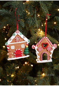 Detailed view of gingerbread house ornaments with red ribbons on a Christmas tree