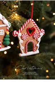 Detailed view of gingerbread house ornament with red ribbon hanging on a Christmas tree