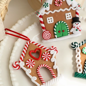 Cute gingerbread house Christmas ornament with red ribbon on a cozy white background