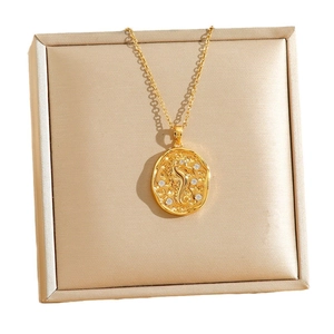 Golden necklace with seahorse relief oval pendant and sparkling white rhinestones