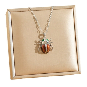 Collier avec pendentif scarabée en acier et émail rouge sur un support en soie chic