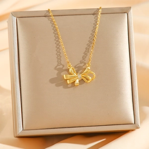 18k gold plated bow pendant necklace with zircons on silk background display