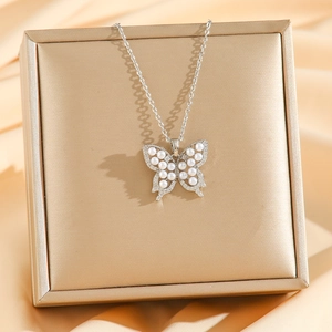 Elegant silver butterfly necklace with inlaid pearls and zircon on gold jewelry box