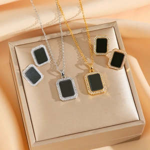 Parure collier et boucles d'oreilles en titane doré et argenté avec pendentif noir