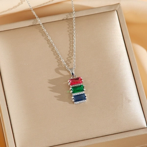 Rainbow gemstone necklace set with red green and blue rectangular stones on a jewelry box
