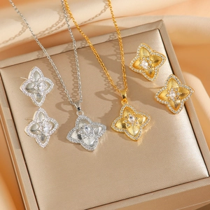 Set di gioielli con quadrifoglio in oro e argento, pietre di zircone e sfondo in seta pregiata