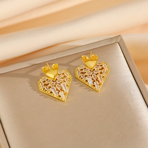 Golden heart earrings with baguette-cut zircons on beige silk background