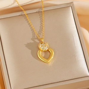 Collana dorata a doppio cuore con zirconi presentata in una scatola regalo di velluto