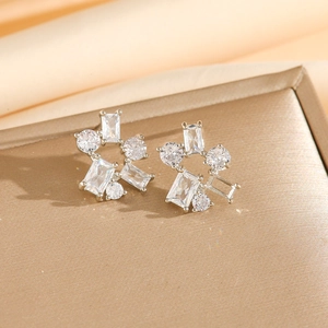Macro shot of silver zircon stud earrings with geometric ice crystal design and claw setting