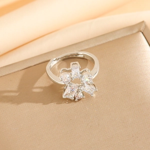 Detailed view of silver adjustable flower ring with sparkling white cubic zirconia stones