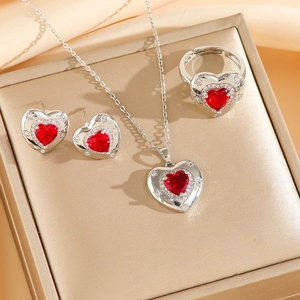Gros plan d'un ensemble de bijoux coeur rouge avec collier boucles et bague