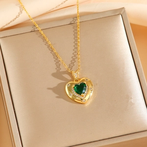Vue détaillée du pendentif cœur en émeraude verte avec cristaux sur chaîne dorée