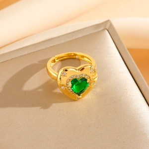 Vue macro d'une bague coeur en or avec émeraude et halo de cristaux scintillants