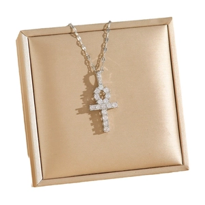 Collier pendentif croix Ankh en argent serti de zircons sur un support de bijoux doré
