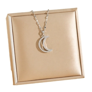 Elegant silver-toned crescent moon necklace with sparkling crystals on jewelry cushion