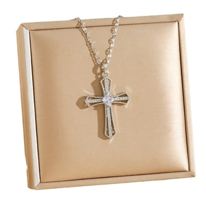 Collier croix en argent avec pendentif en zircon dans un écrin à bijoux en velours champagne