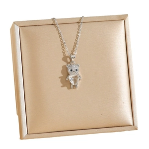 Collier pendentif ours argenté avec zircon en cœur sur un coffret à bijoux en soie