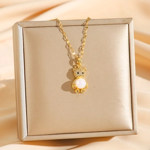 Collier avec pendentif ours doré avec perle et cristaux brillants sur fond de satin