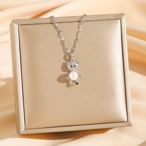 Collier pendentif ours avec zircons et perles sur une boîte à bijoux de luxe raffinée
