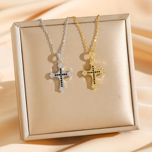 Gold and silver twisted chain necklaces with paved cross pendants on silk display
