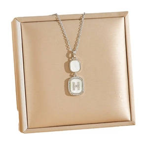 Elegant silver titanium necklace with H-letter pendant and shell inlay on satin display