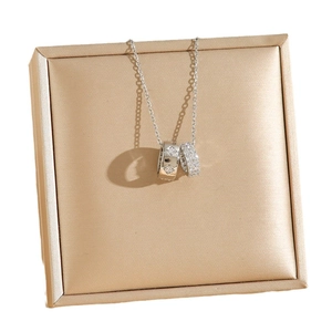 Titanium steel double ring necklace with sparkling crystals on champagne jewelry box