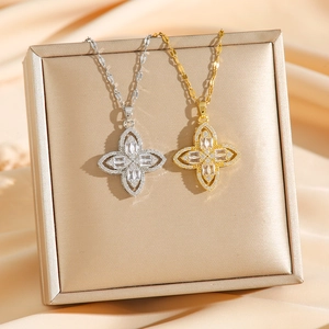 Exquisite gold and silver clover necklaces with zircons on a luxury jewelry box display