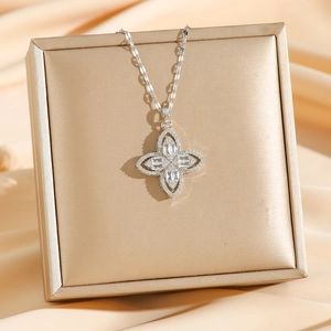 Sparkling silver four-leaf clover necklace with pave zircons on champagne satin background