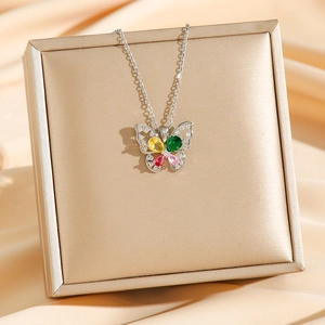 Colorful butterfly zircon pendant necklace on luxury gold box and beige silk background