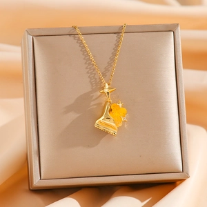 Goldene Bärenkette mit gelbem Harzanhänger und Sterndetail auf champagnerfarbenem Satin
