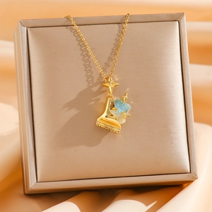Detail der Goldkette mit blauem Harz und Zirkon-Sternen auf Seidenhintergrund