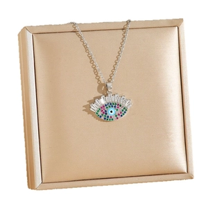 Collier rétro Mauvais Œil avec zircons colorés pavés sur un présentoir en satin doré