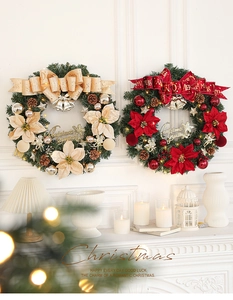 Detail of a lit Christmas wreath with red flowers and glowing warm LED fairy lights