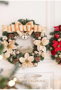 Close-up of lighted Christmas wreath with pine cones and bells on a white fireplace