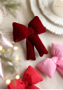 Detail of red velvet and satin pink bows on a festive table with pearls and lights