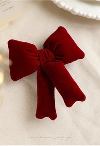 Close-up of a premium red velvet Christmas tree topper bow with elegant long ribbons