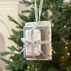 Close-up of decorative Christmas gift box ornaments with sequins and silver ribbons on a tree