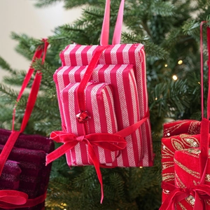 Close-up of assorted festive Christmas mini gift box ornaments with velvet ribbons and bells