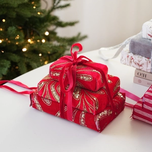 Close-up of red velvet Christmas gift box ornaments with golden sequins and ribbon ties