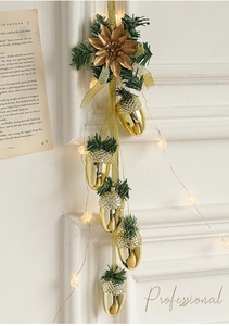 Detail of gold pine cone ornaments with faux needles and warm white LED string lights
