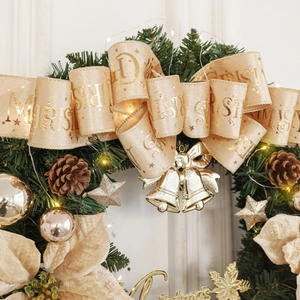 Illuminated Christmas wreath with champagne ribbons, gold bells, pine cones, and LED lights