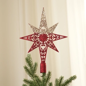 Detail of red and silver glitter star tree topper with heart patterns on a Christmas tree